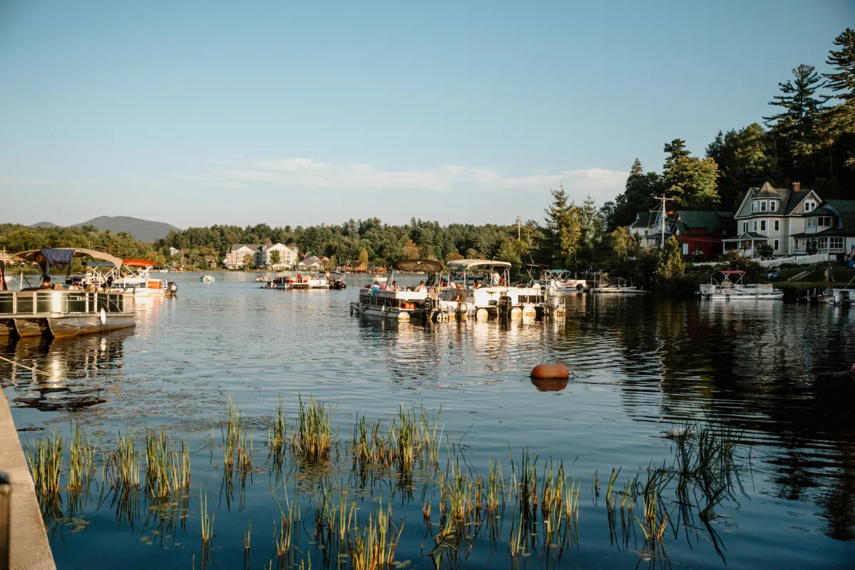 Pontoon boats at rest at a small lakeside dock in a quaint small town.