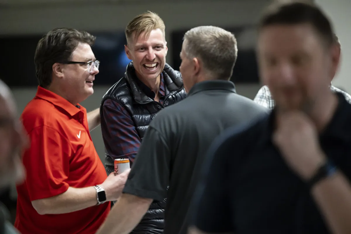 A group of men talk at a convention.