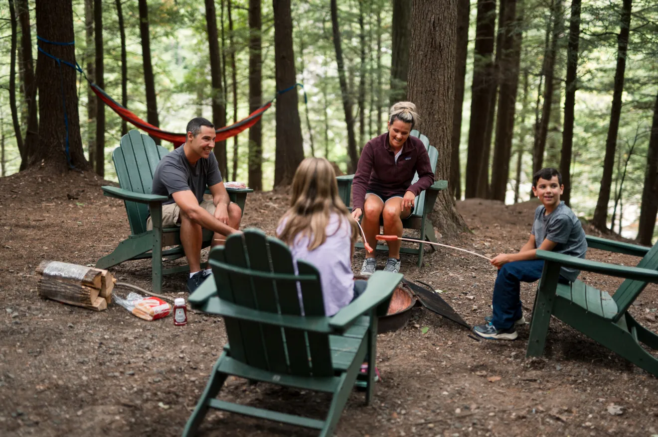 A family of four all sit in Adirondack chairs and 