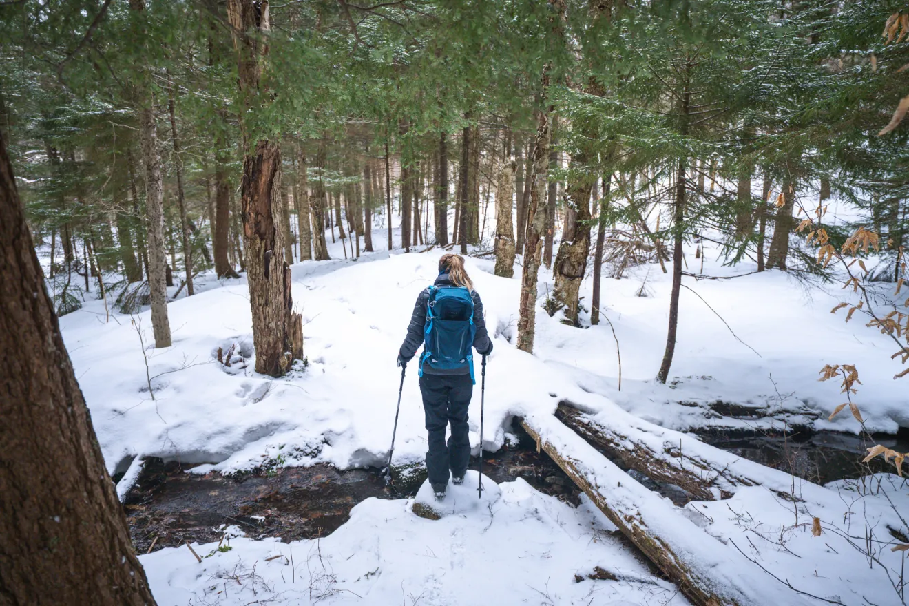 A woman snowshoe hikes in the winter. 