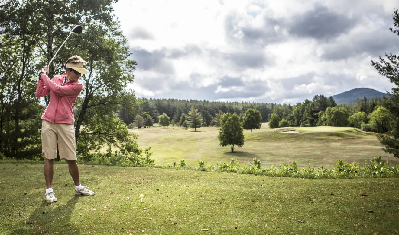 A woman golfing in Ray Brook.