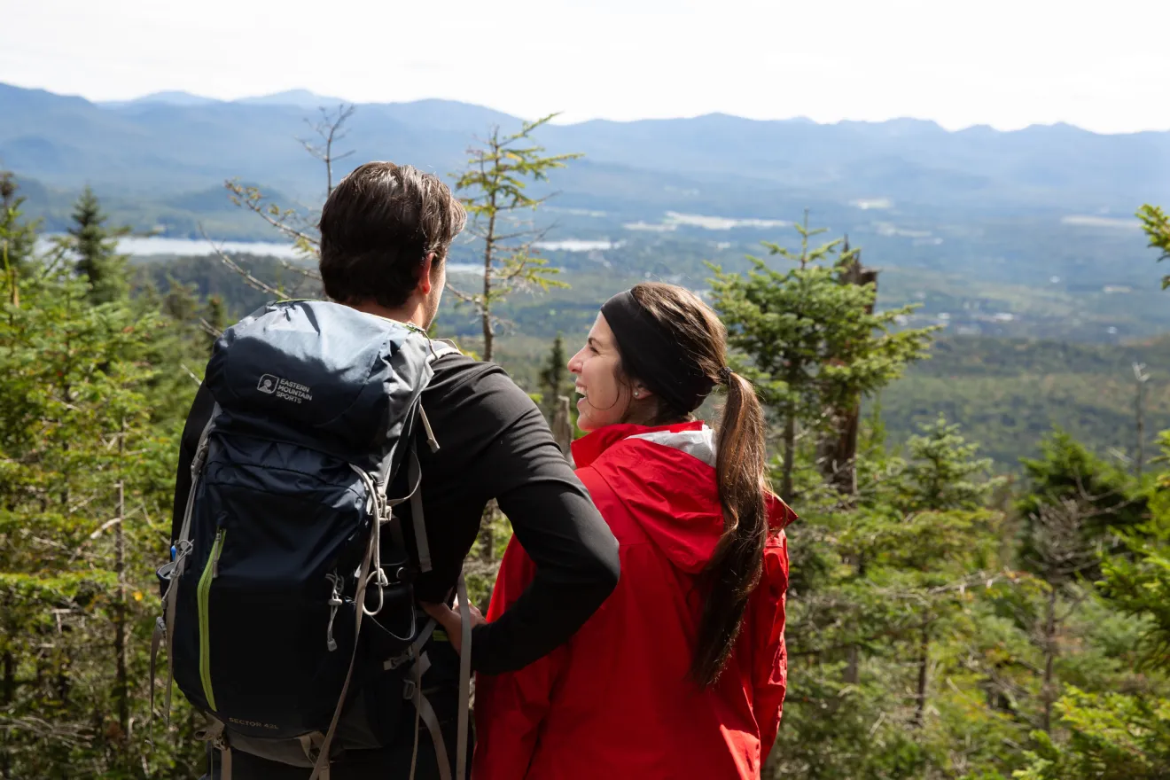 A man and woman look out to a mountain range.