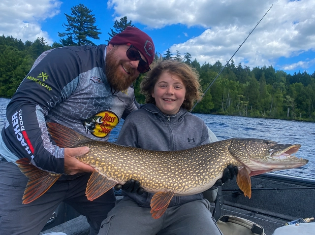 A man and a child hold a pike.