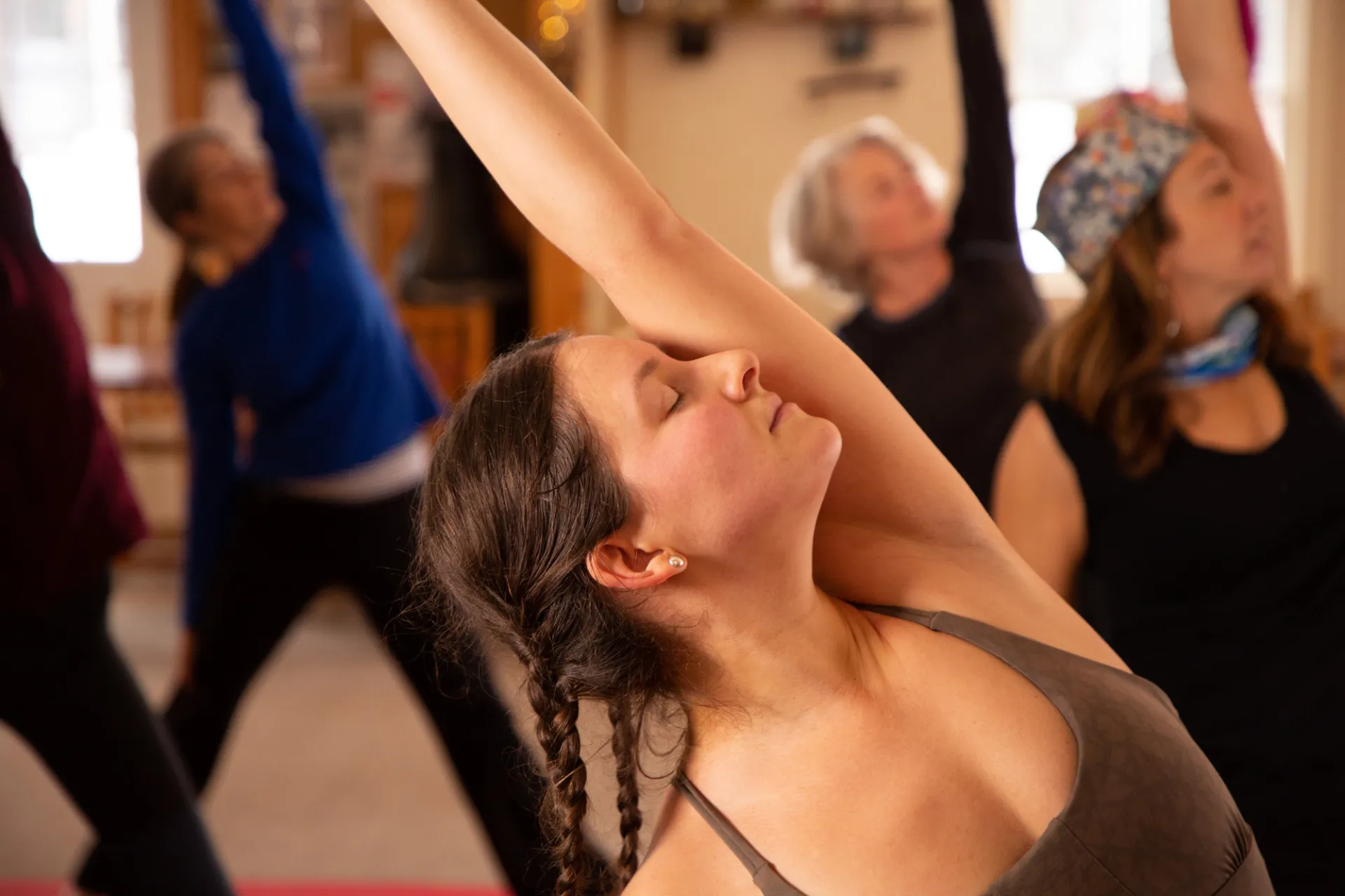 A group of women do yoga in a room. 