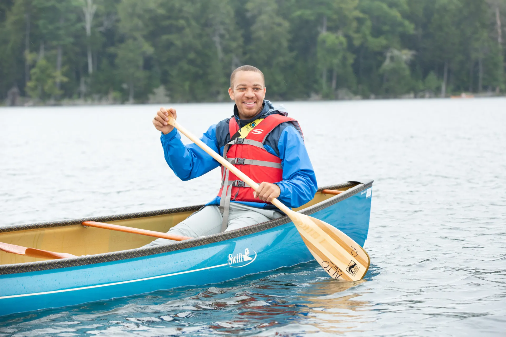 A person paddling a canoe in Saranac Lake.