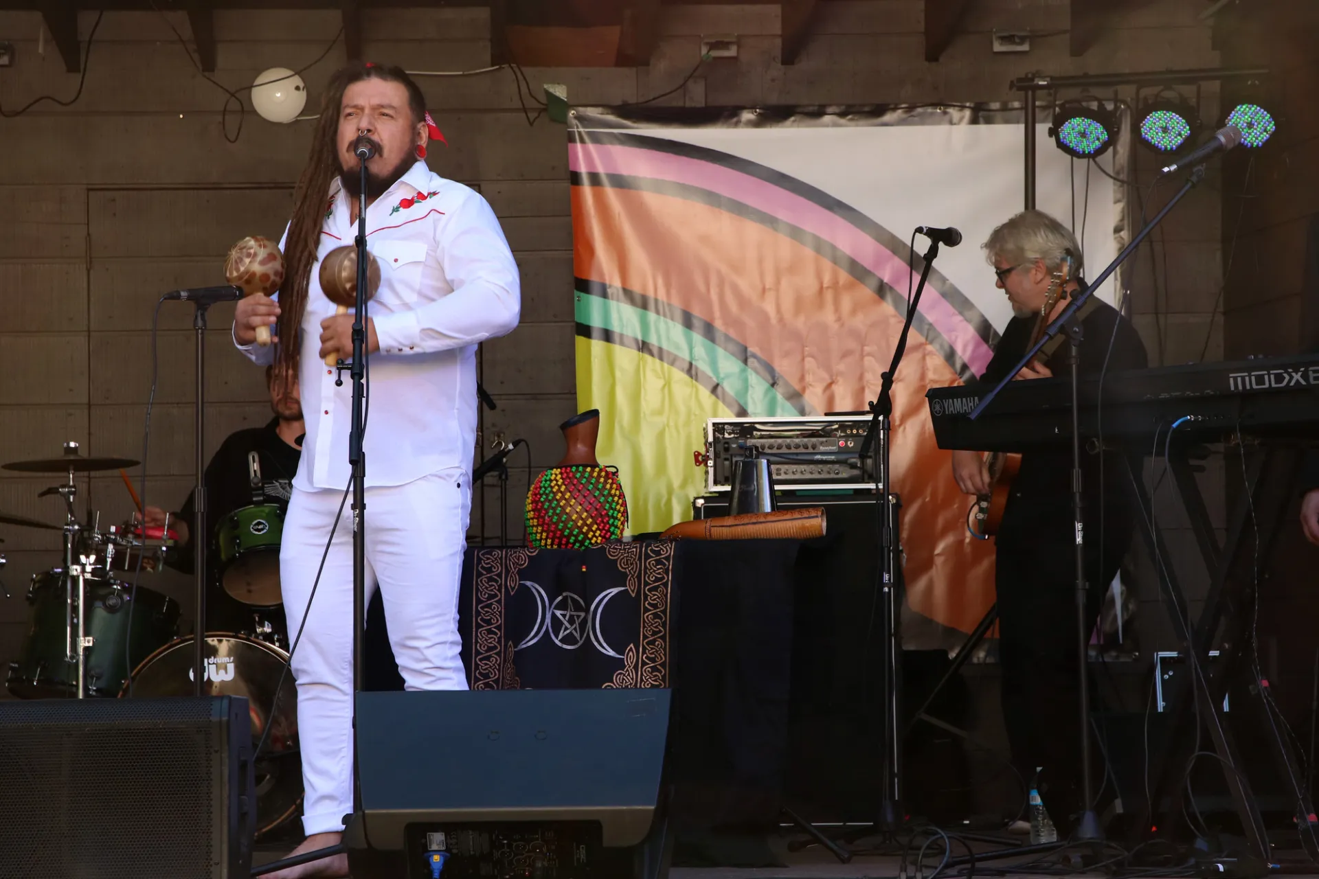 A man with maracas sings his heart out from the band shell