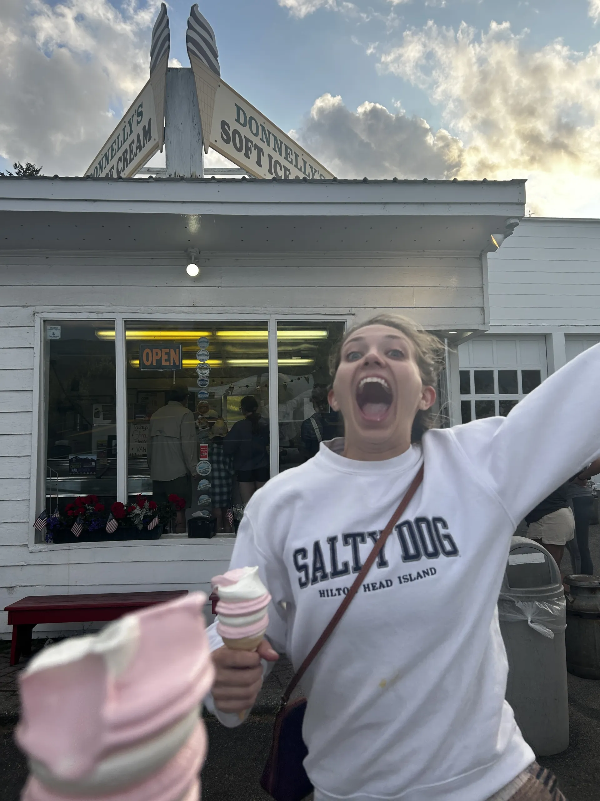 A woman screams in front of a small ice cream stand.