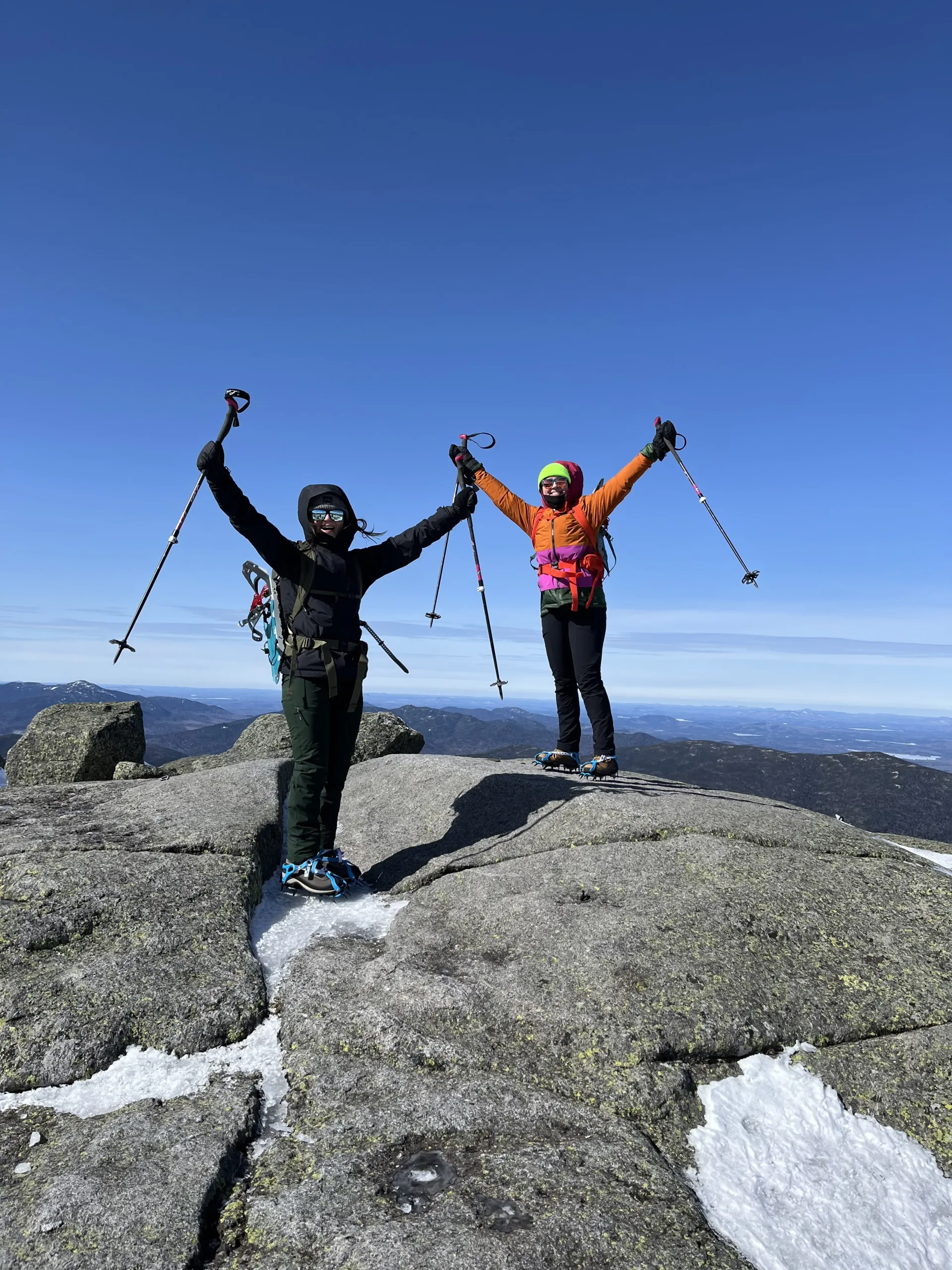 Mountaineers throw their hands in the air in celebration after ascent