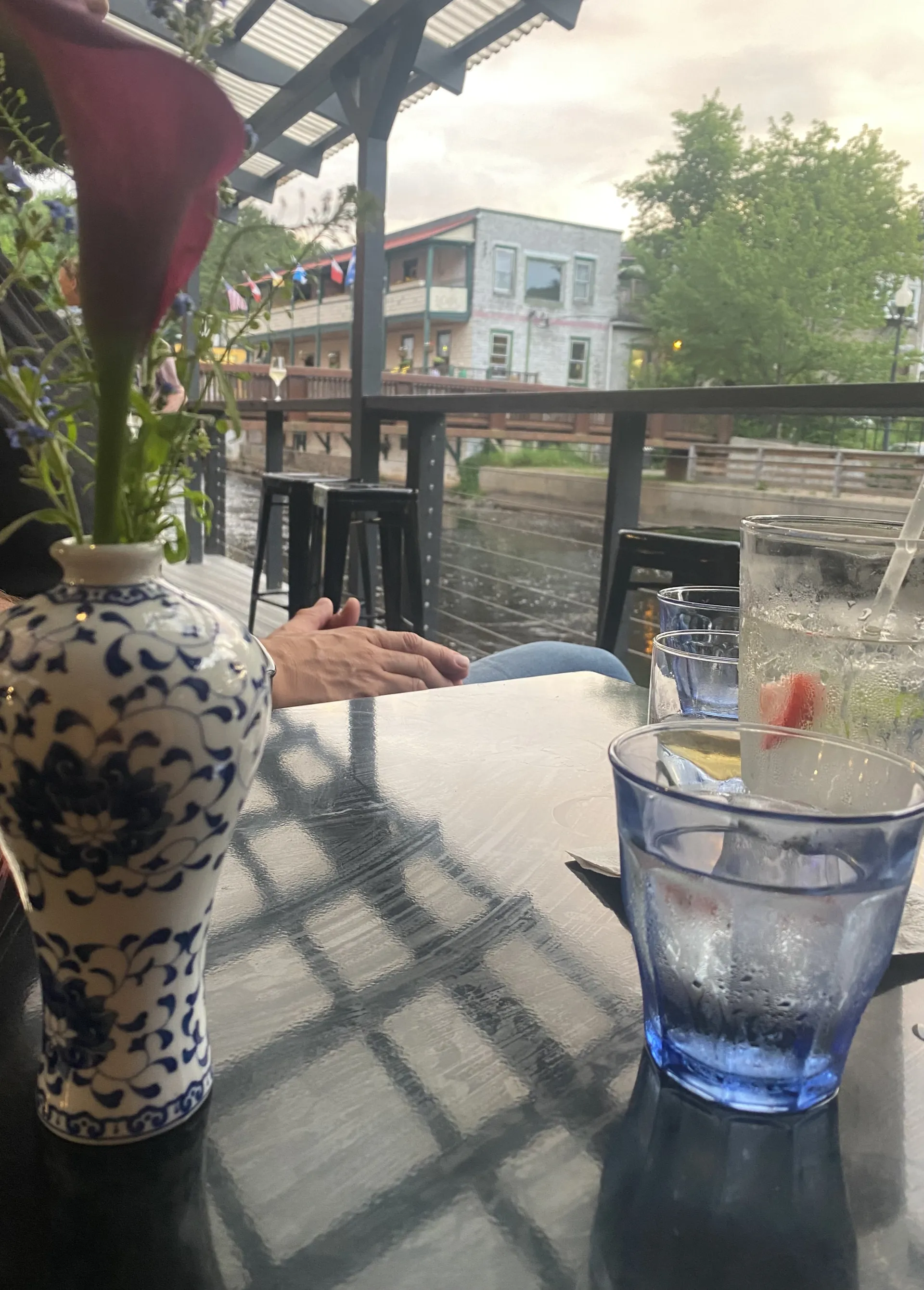 Sitting on the terrace looking over the river with a cocktail on the table 