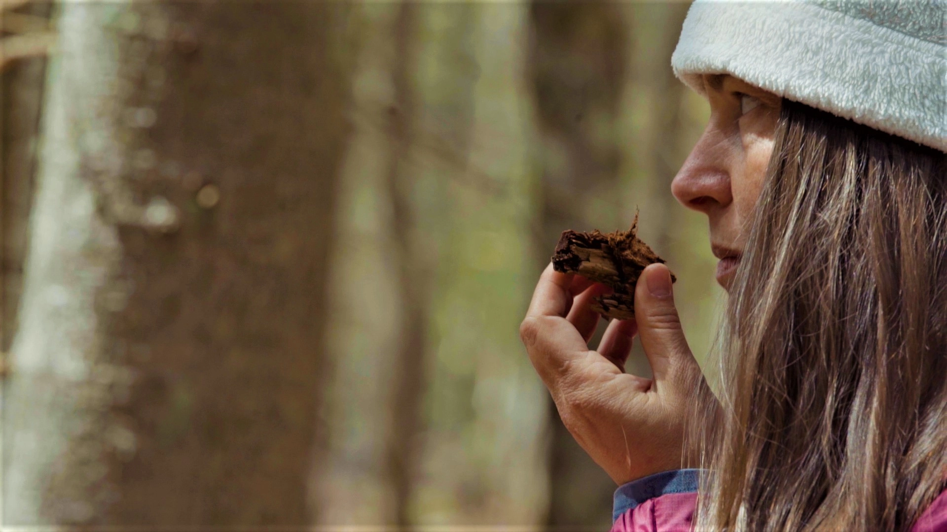 A woman engages her sense of smell to inspect a mushroom 