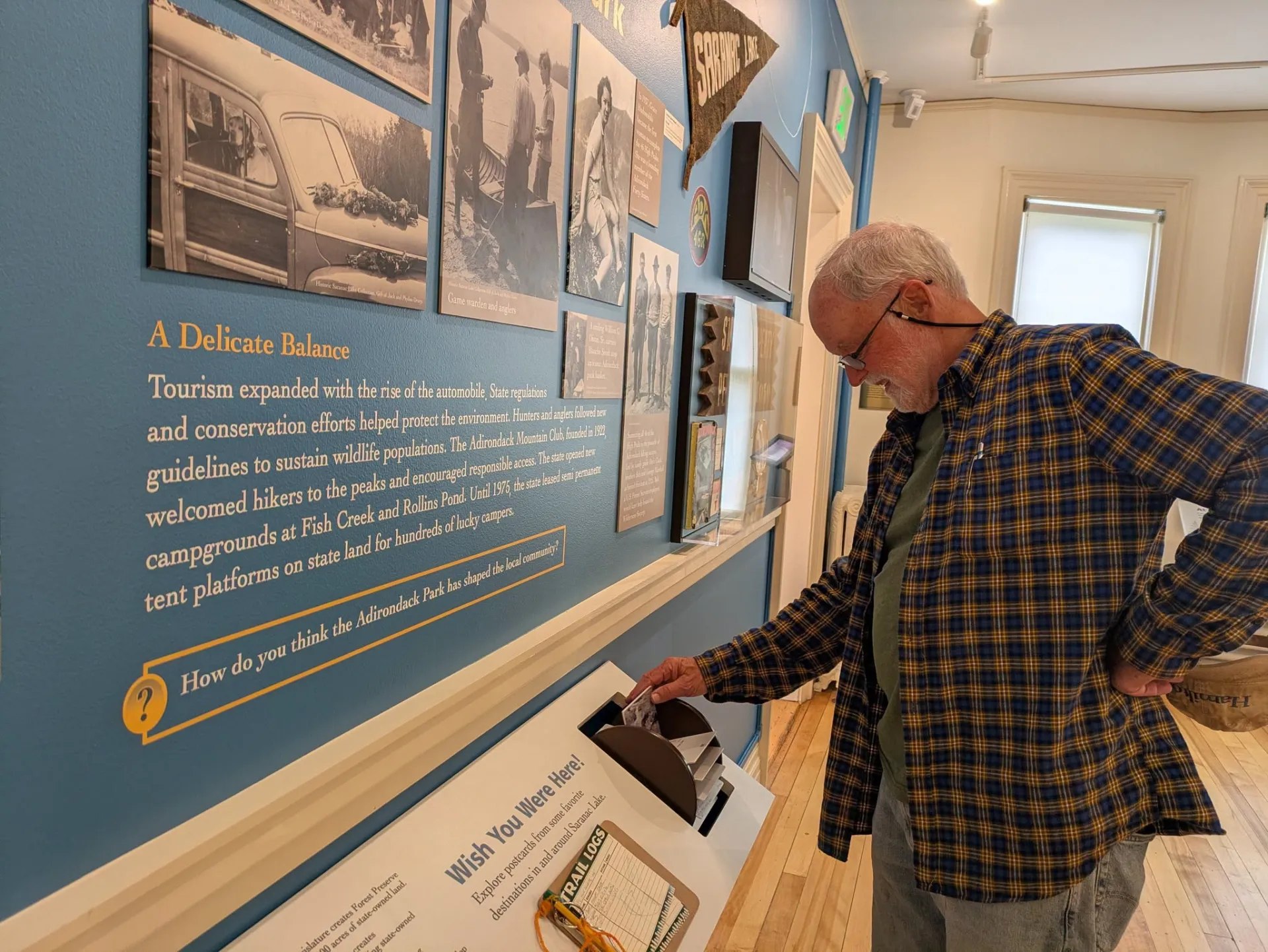 A man flips through an interactive exhibit display at a museum.