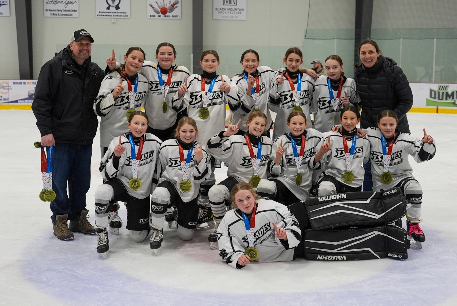 A group of young female hockey players celebrating their victory at the Empire State Winter Games.