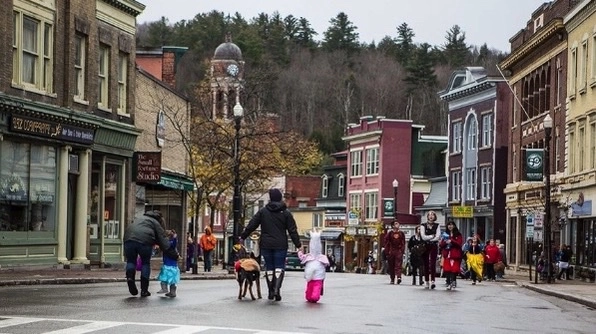 A small-town street scene with people walking,.