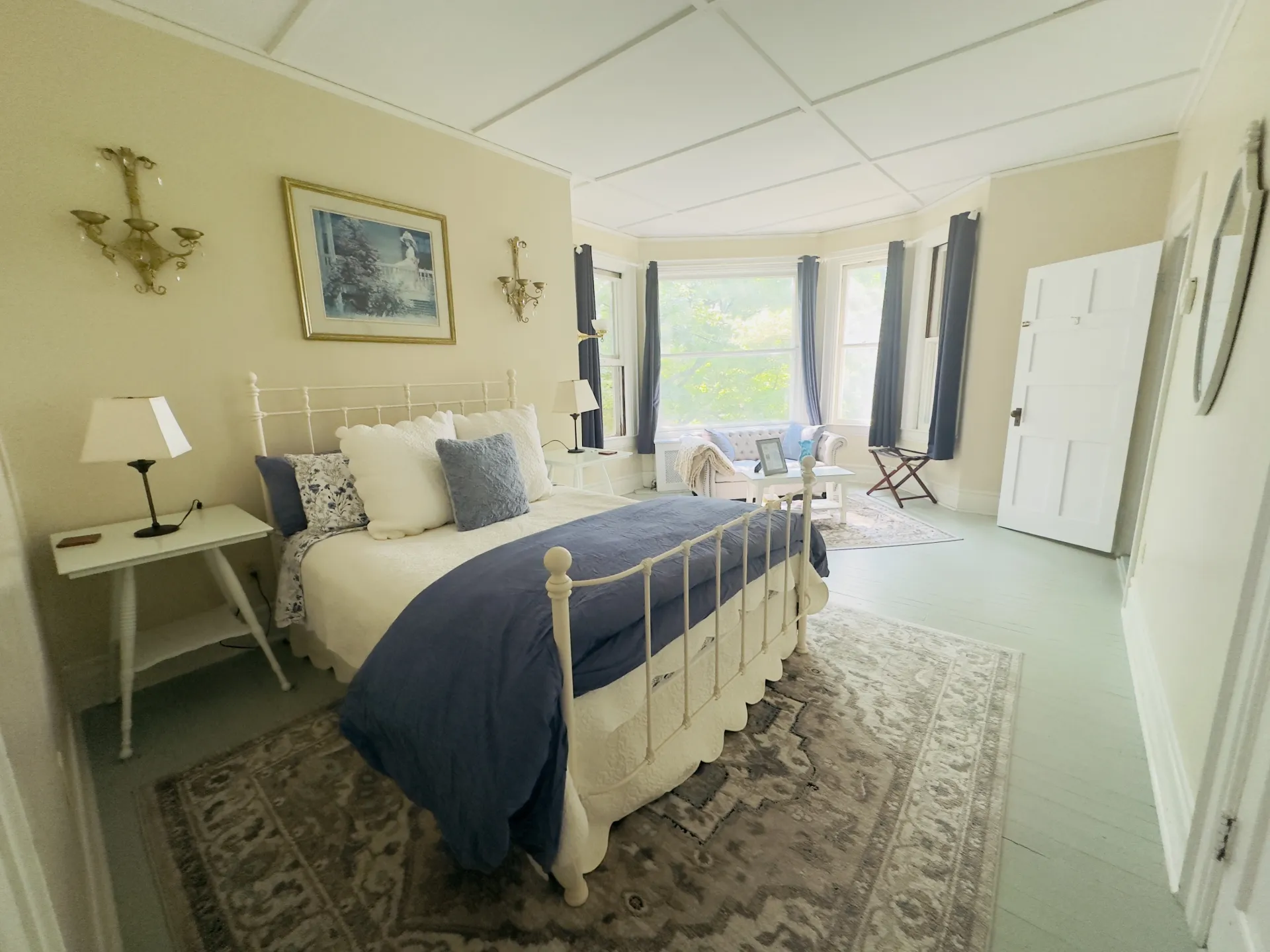 A large bay window beckons you into the room past a large lux bed 