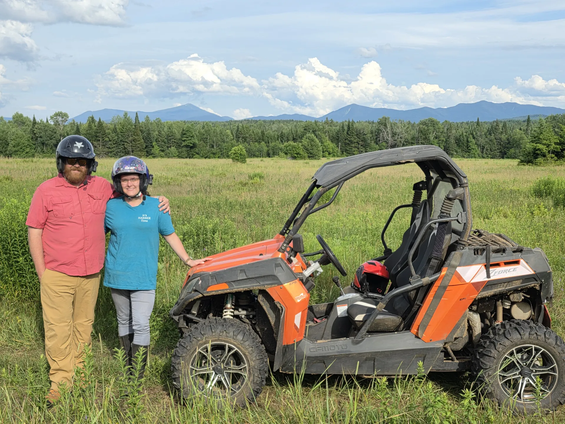 A couple standing next to a UTV.