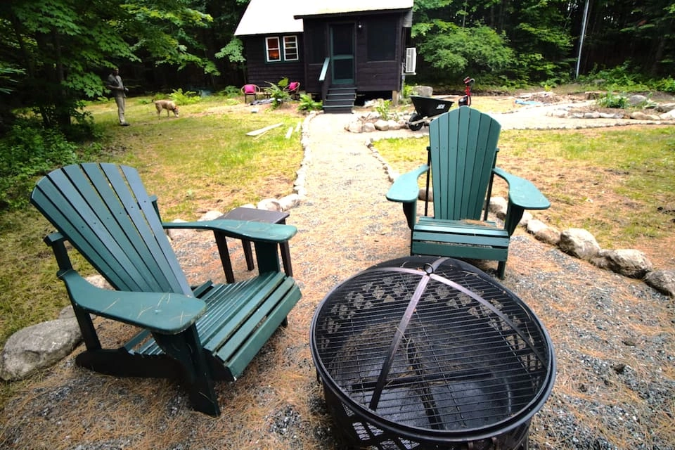 Outdoor fireplace and green adirondack chairs at Rockledge Cabins & Retreats 
