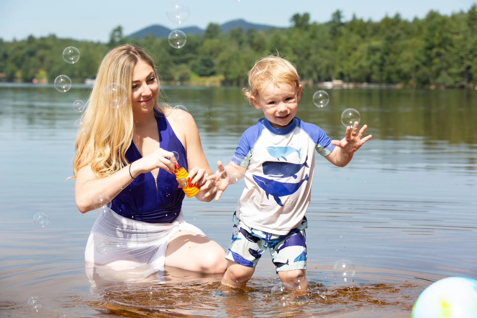 A mother and her child play in the water in Lake Clear