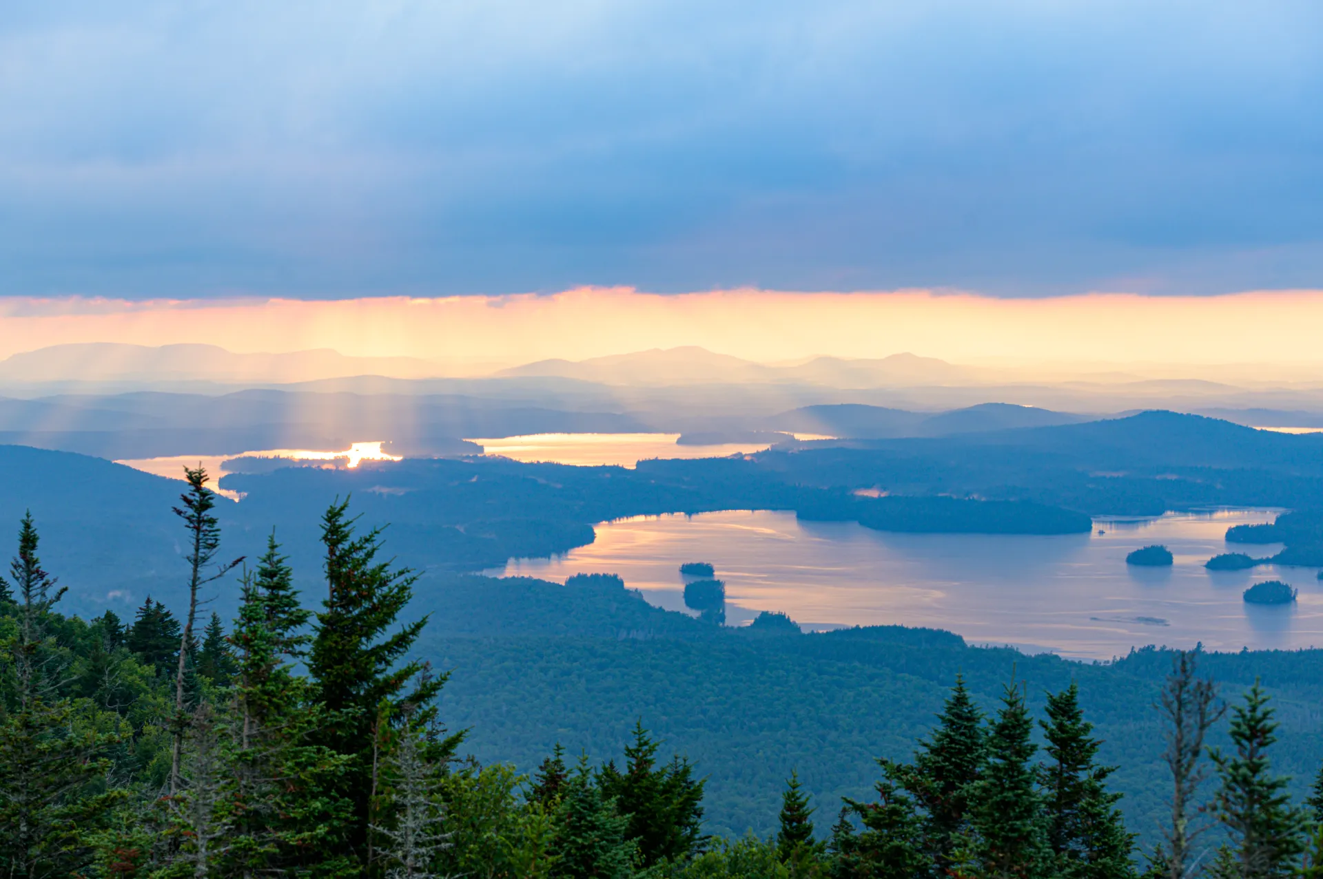 Stunning view of the reflection of the sunrise in a lake from the top of Ampersand Mountain