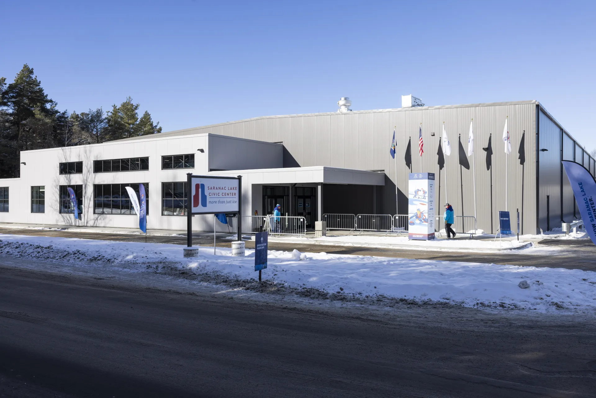 A snowy exterior of the Saranac Lake Civic Center and sign.
