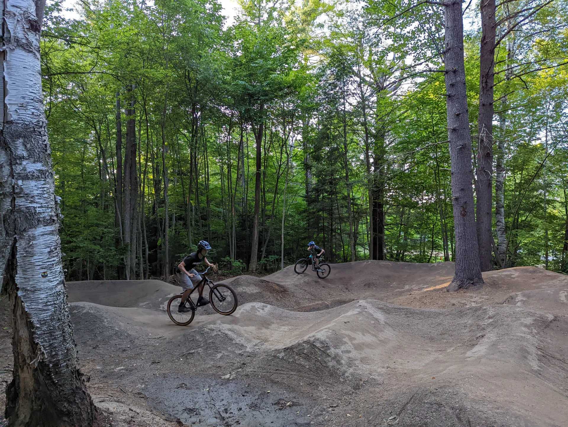 A kid jumps a dirt ramp on his bike