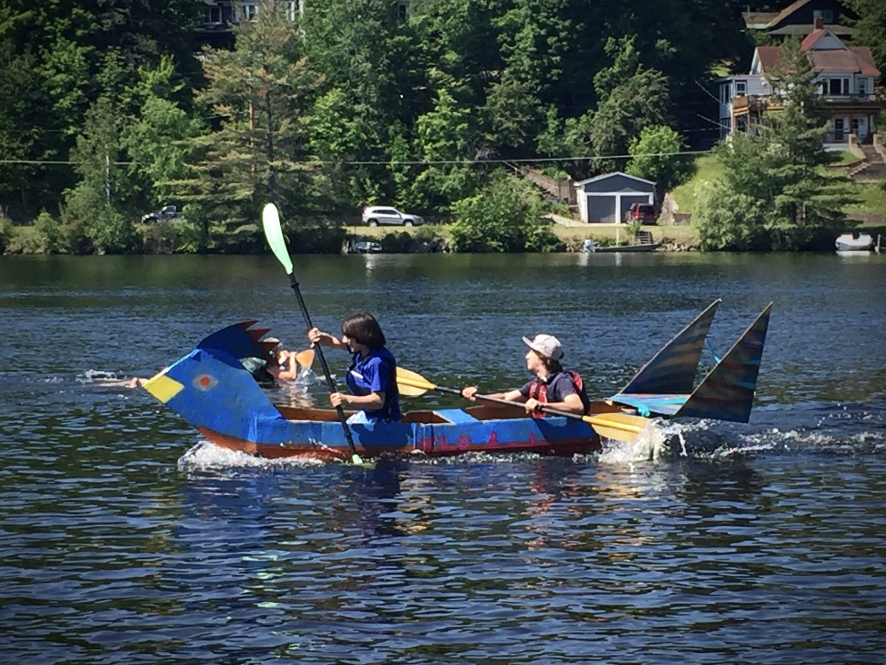 children in a handmade and hand painted cardboard boat on lake flower