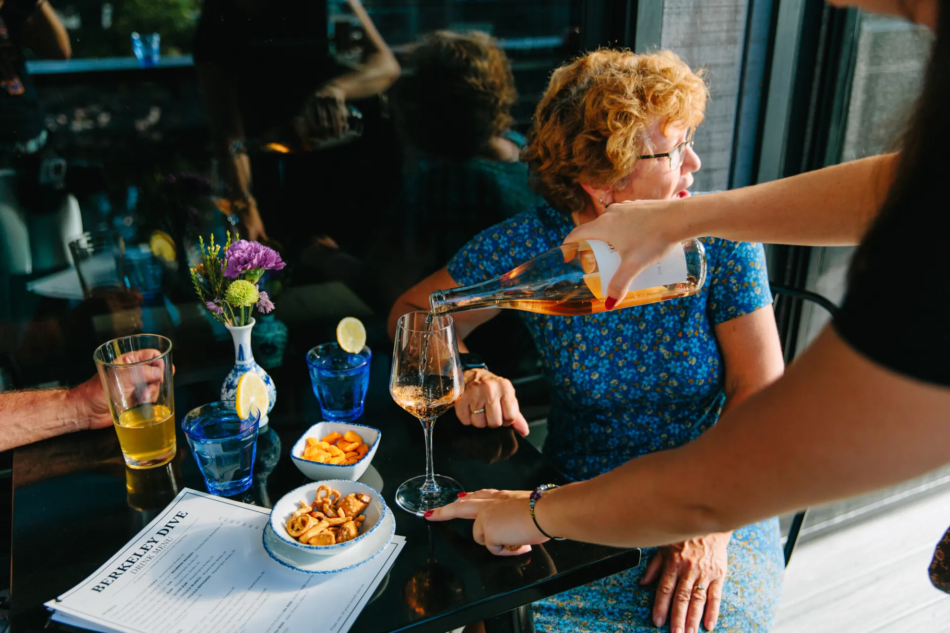 A woman pouring a glass of wine.