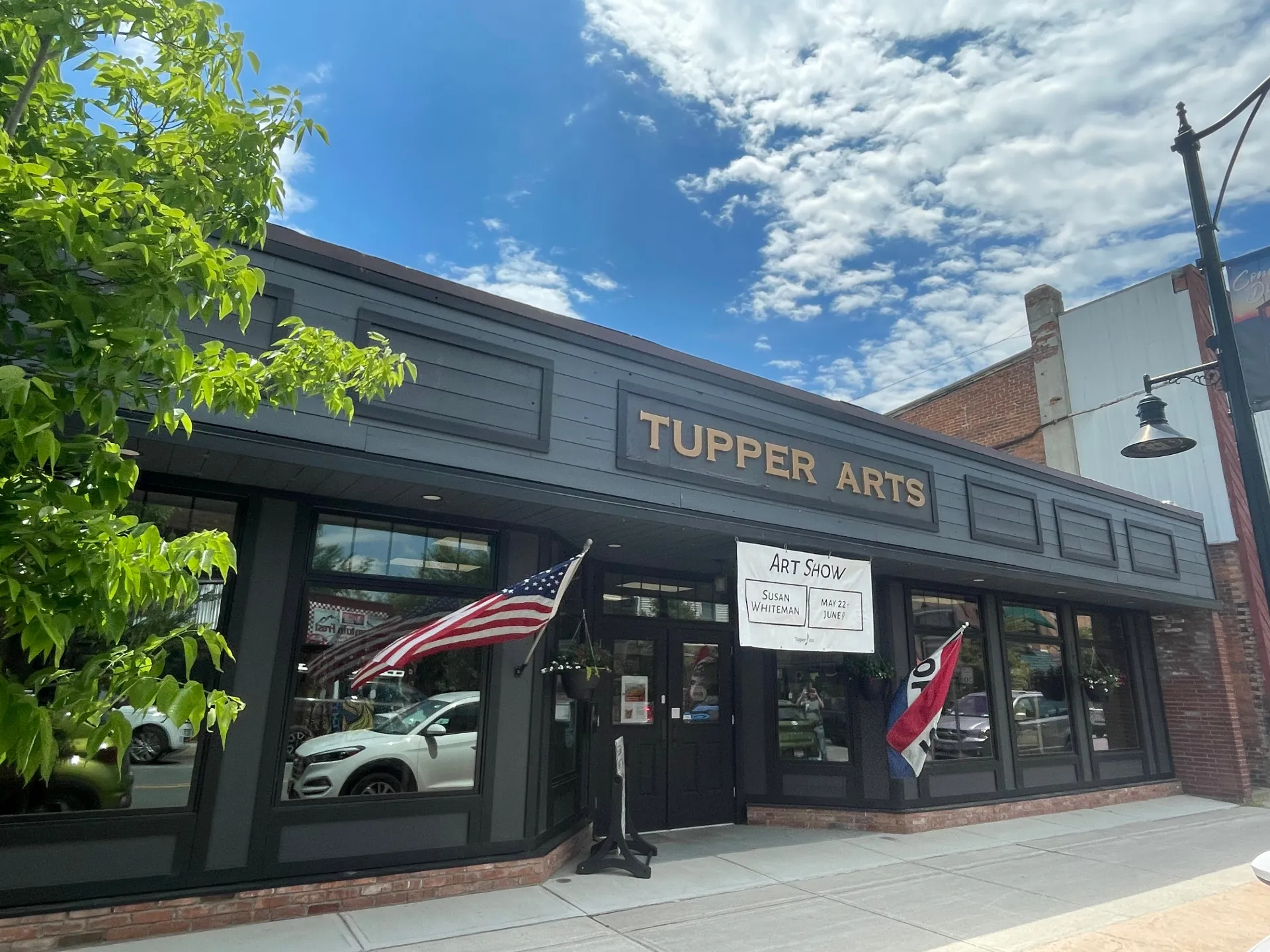 The exterior of Tupper Arts with blue skies and fluffy clouds above.