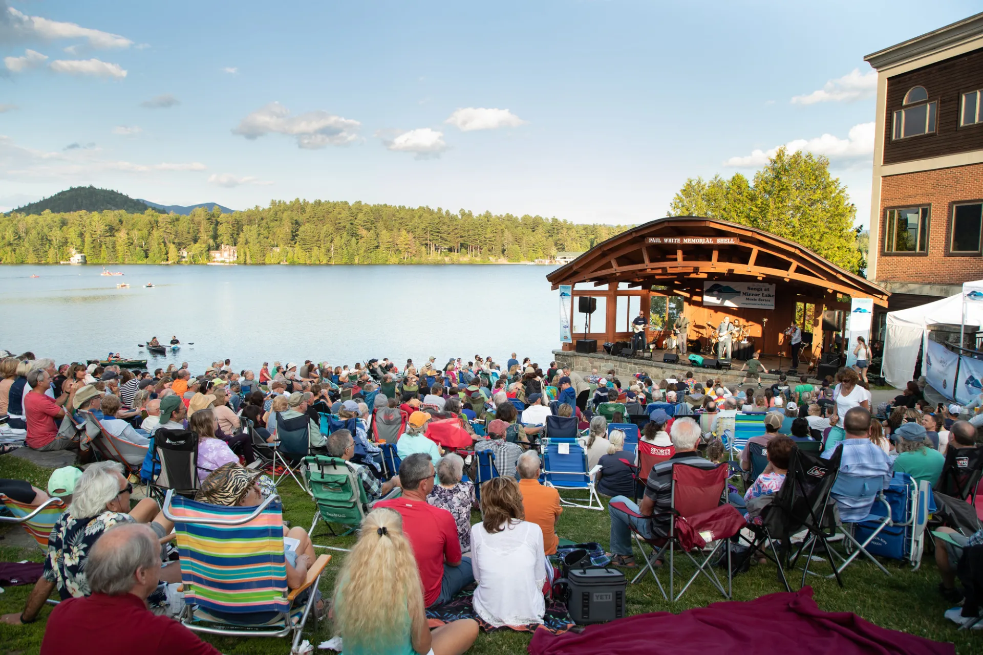 A crowd gathered in front of the band shell at Mid's Park, a hillside between Main Street and Mirror Lake in Lake Placid NY