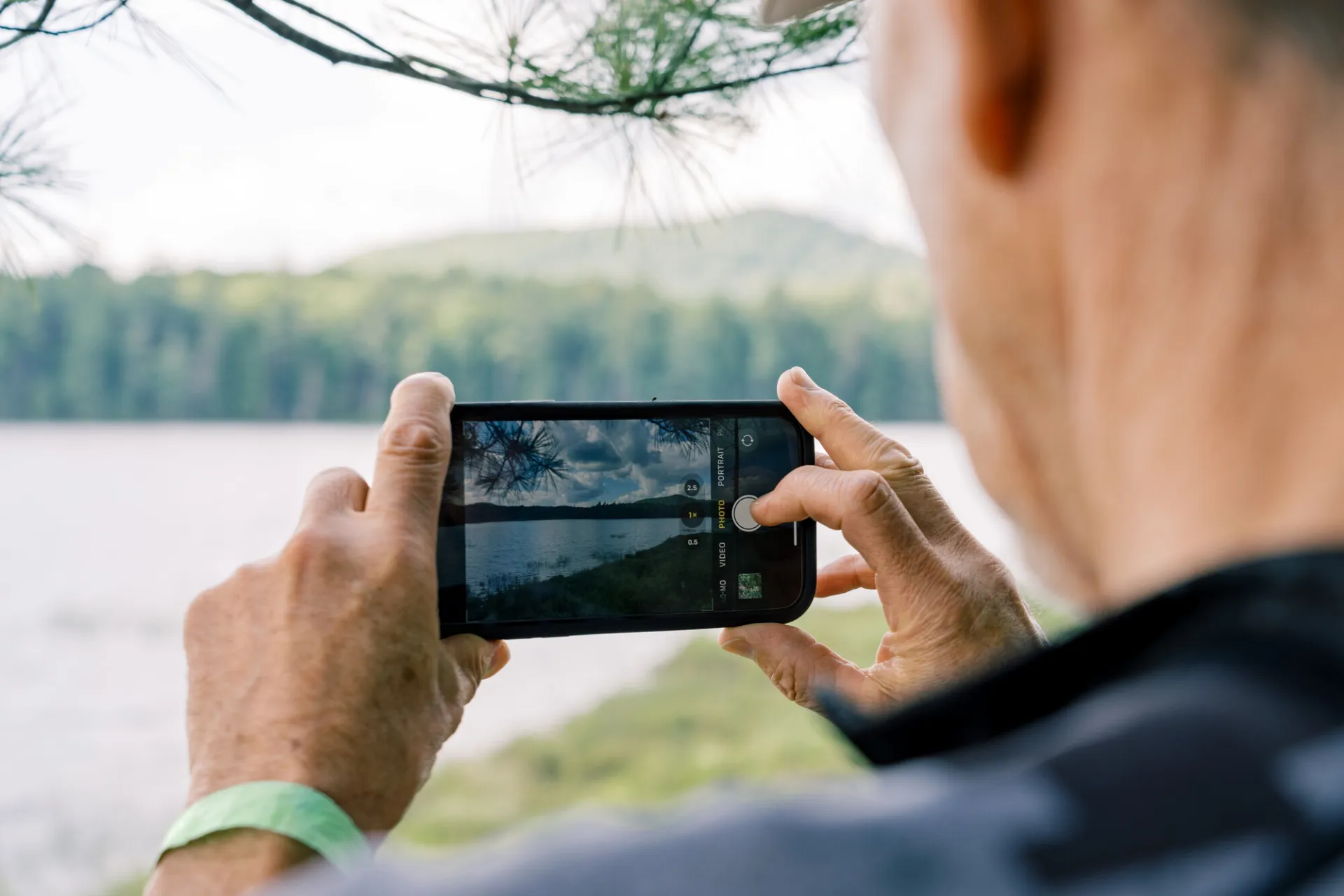 A person taking a photo of a lake.