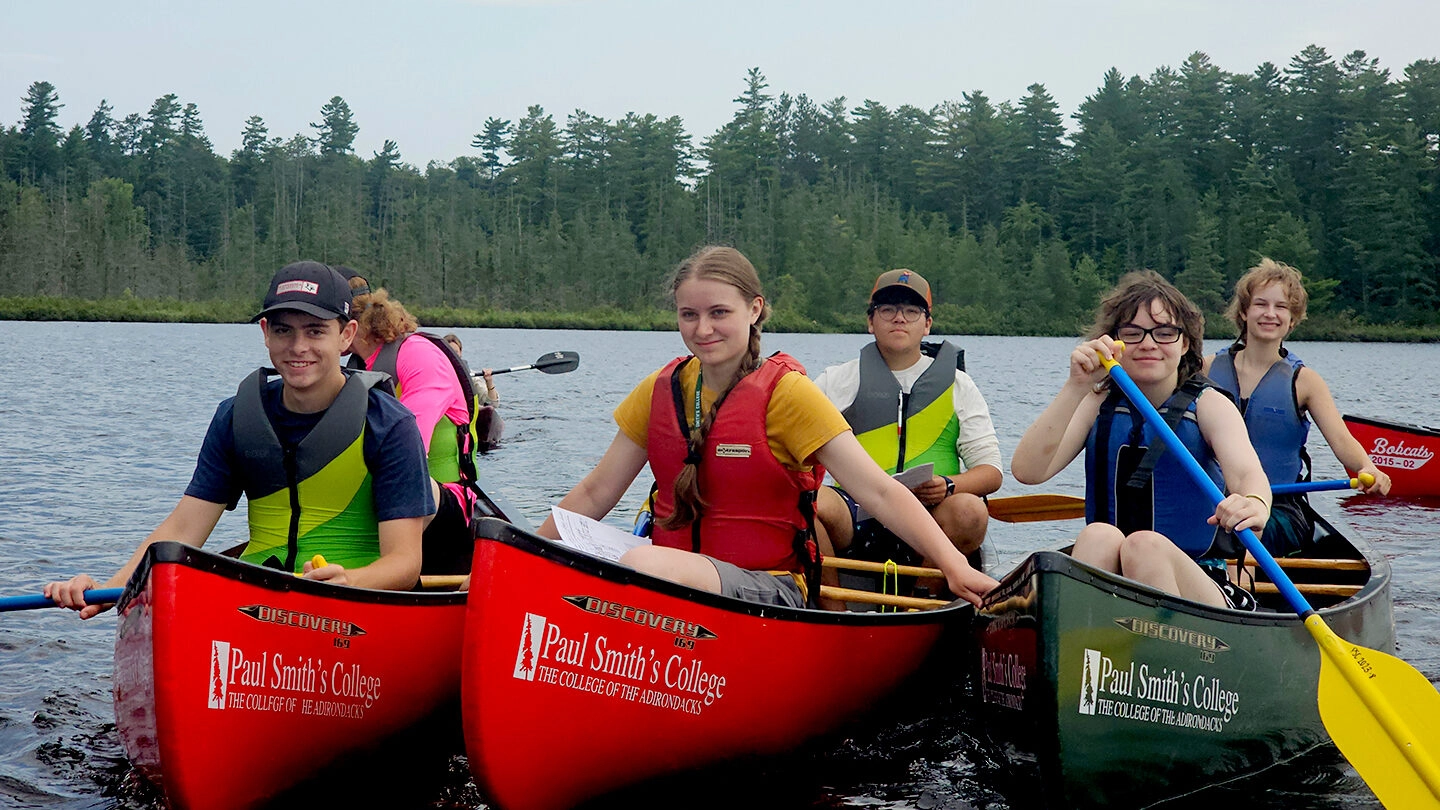 group of children in canoes on the water