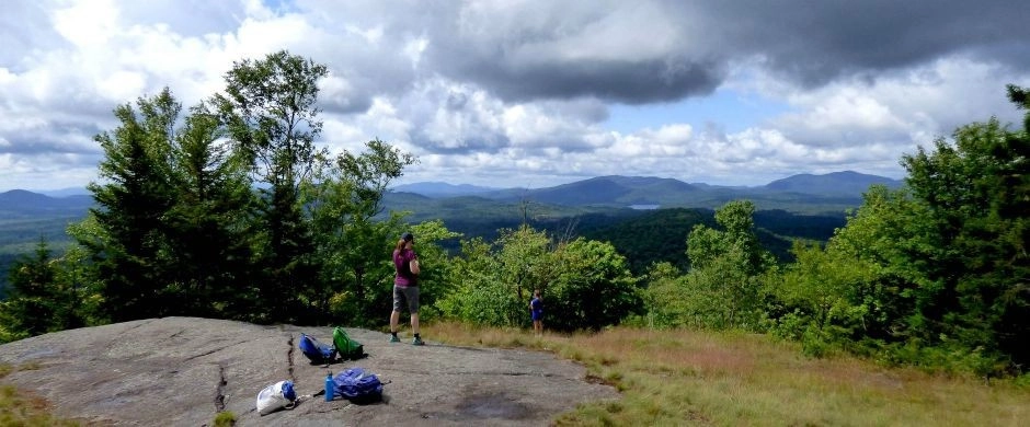 A hiker stands on partially open summit
