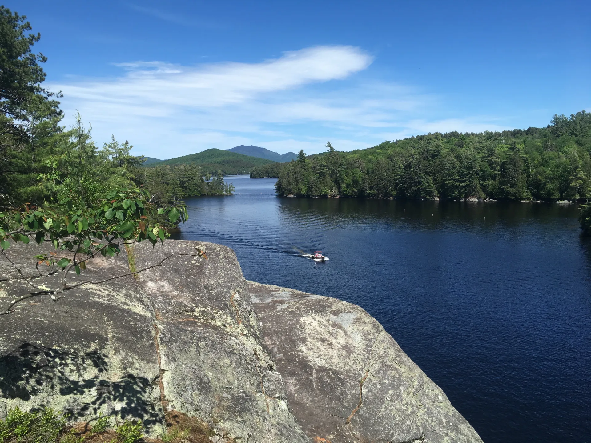 View of a motorboat from the shore of Lower Saranac Lake