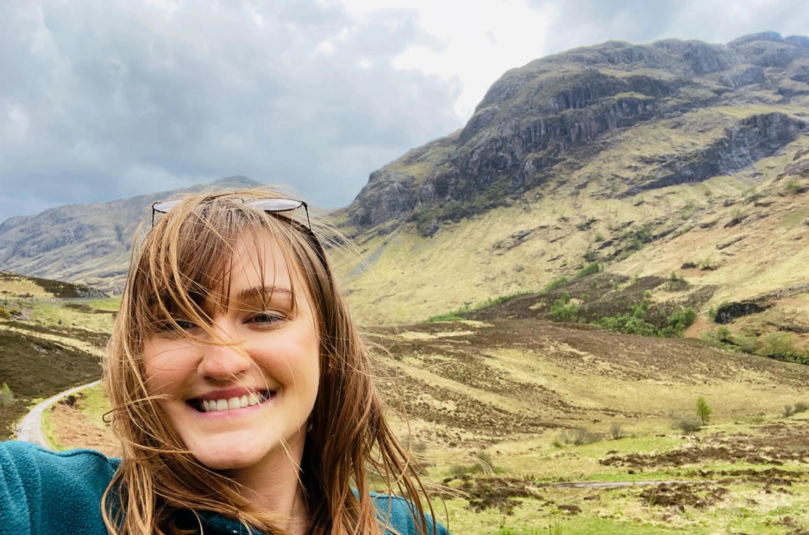 A selfie of a woman with a scenic background.