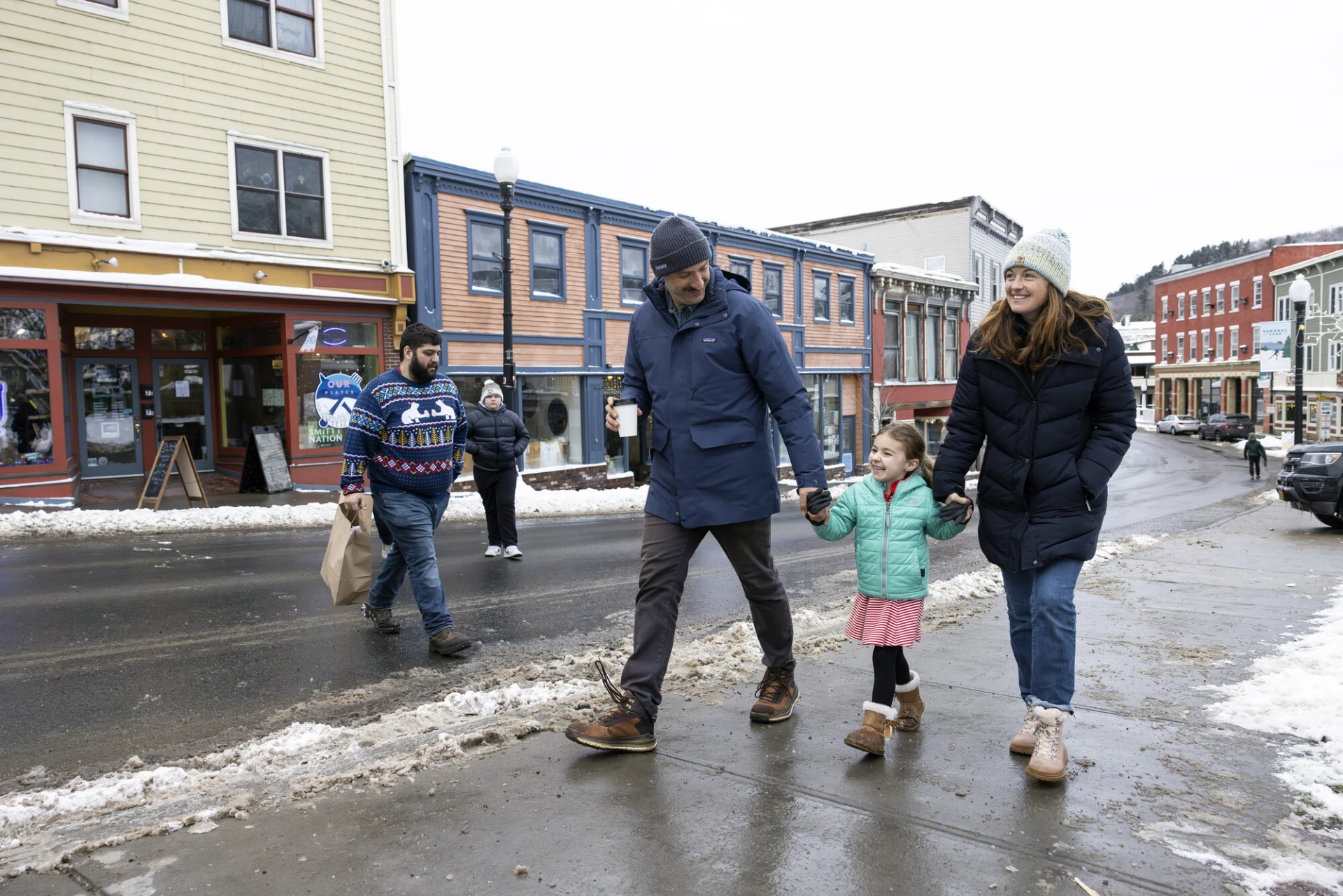 family walking on snowy street 