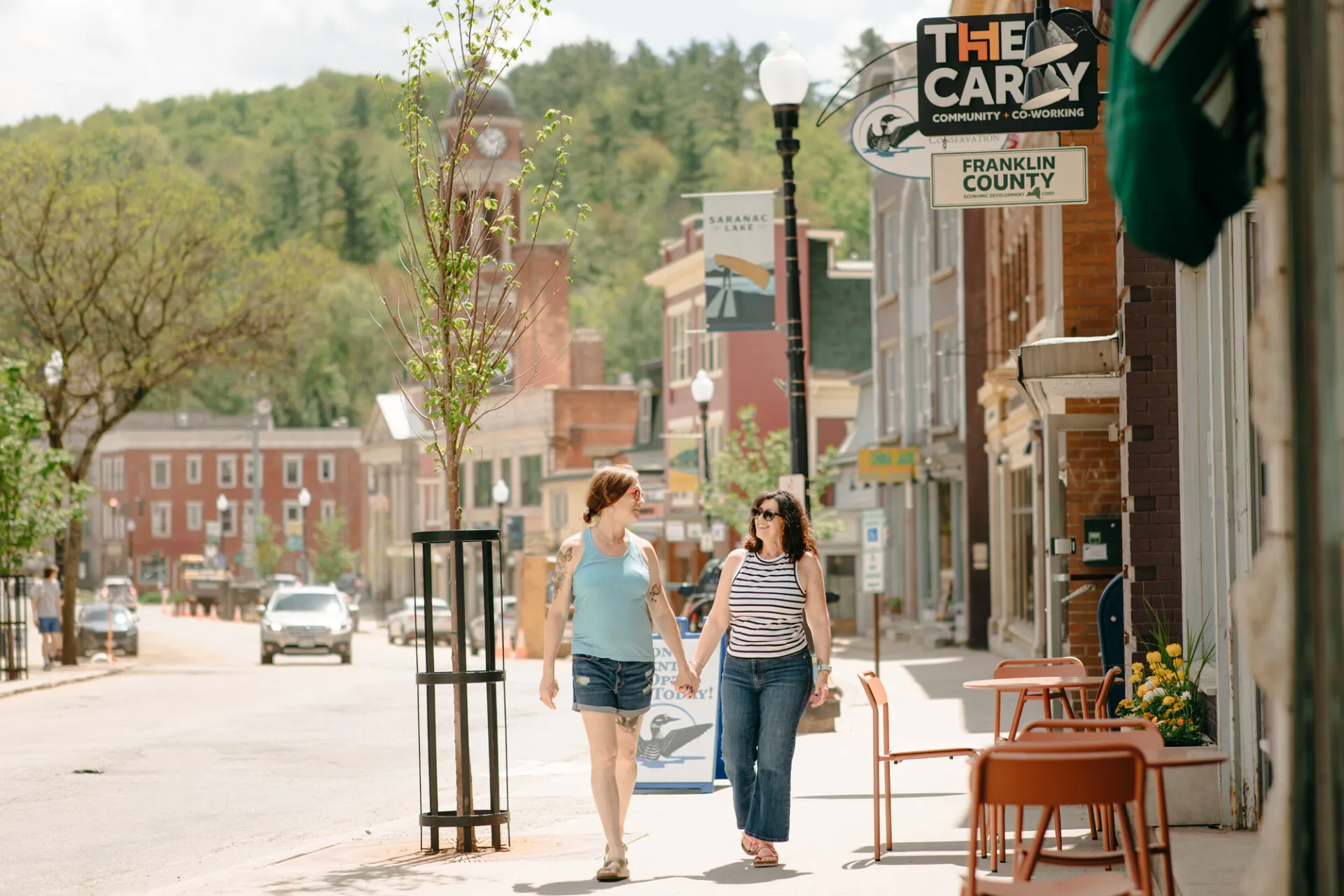 Two women walk on a main street 