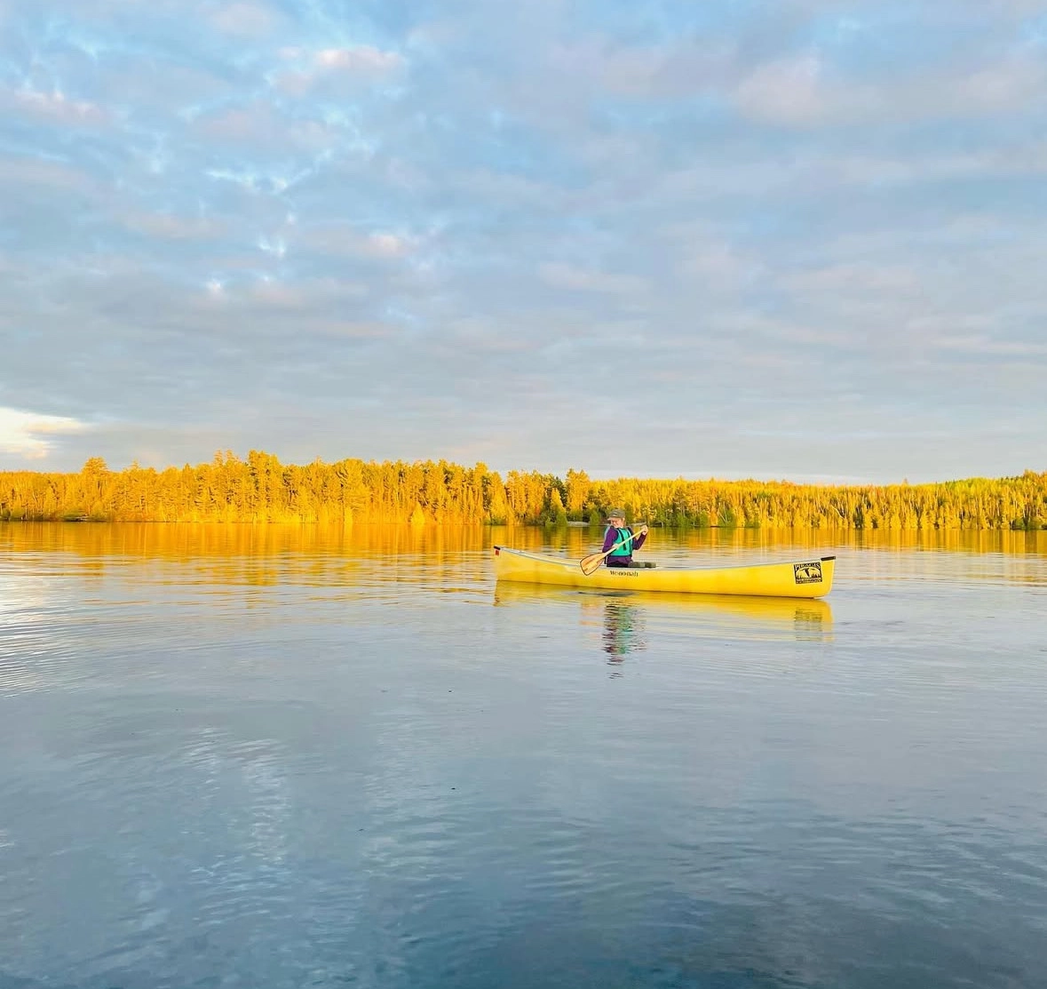 A woman paddling a canoe.