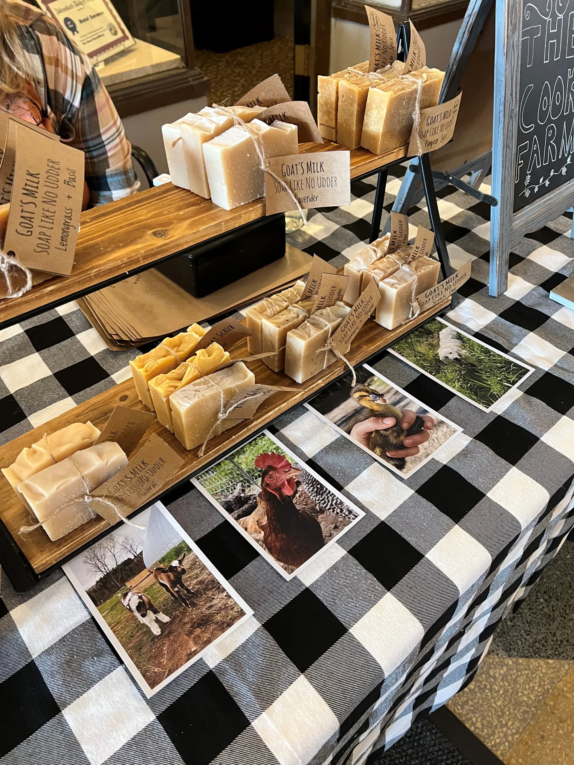 A table with a checked table cloth and handmade soaps on display. 