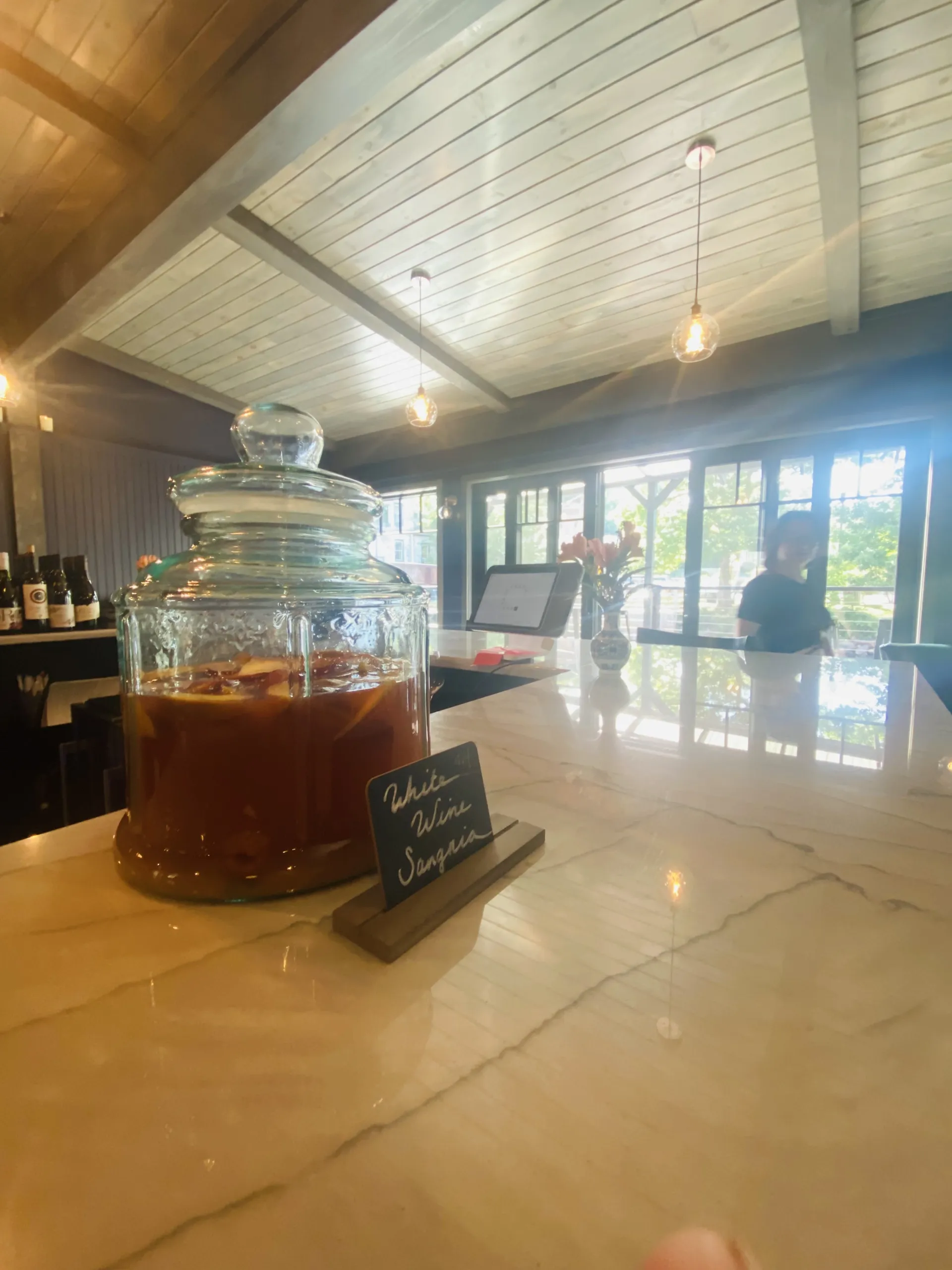 Sangria sitting in a large glass jar on top of the granite counter of the bar
