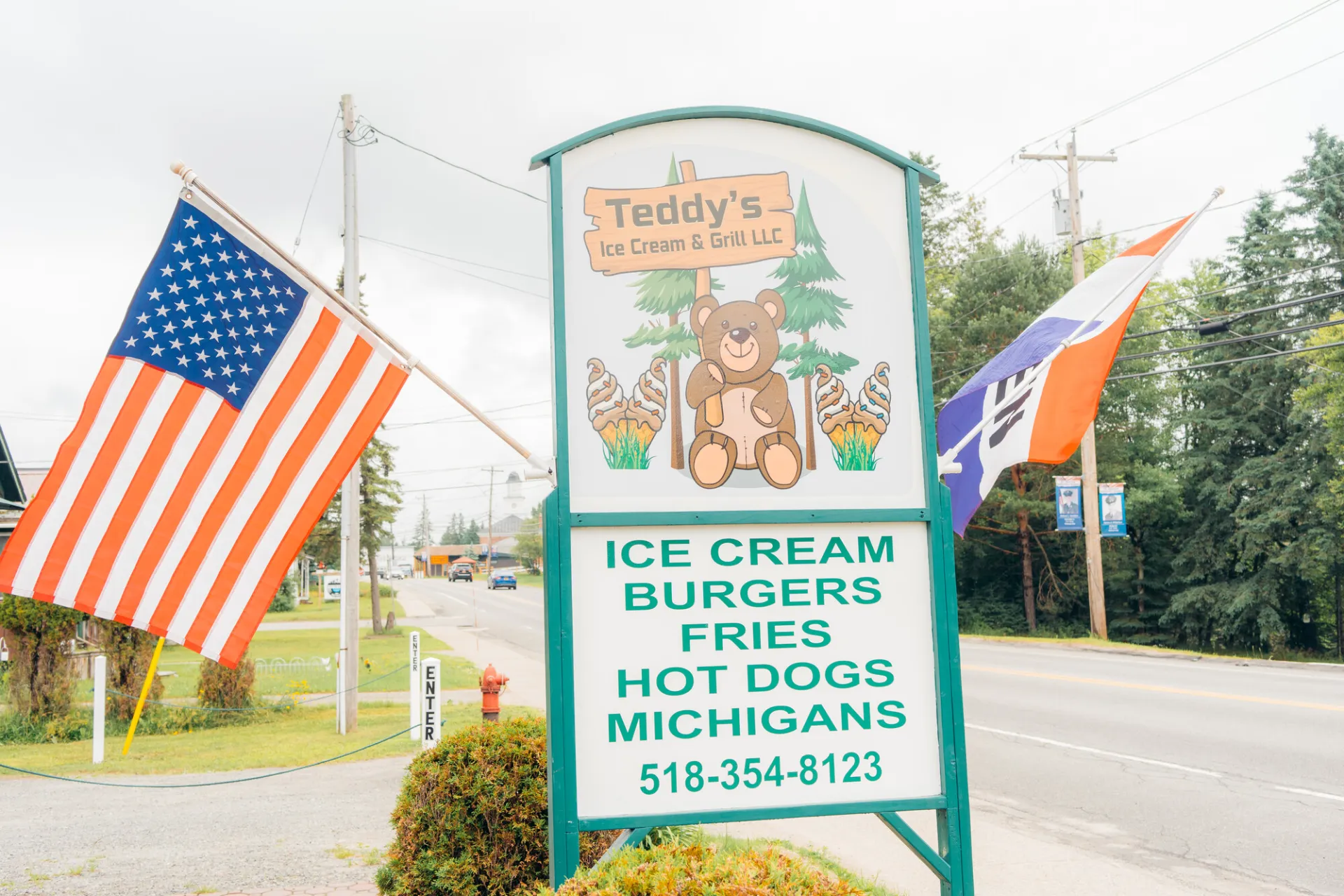 A sign for Teddys Ice Cream on the side of a road.