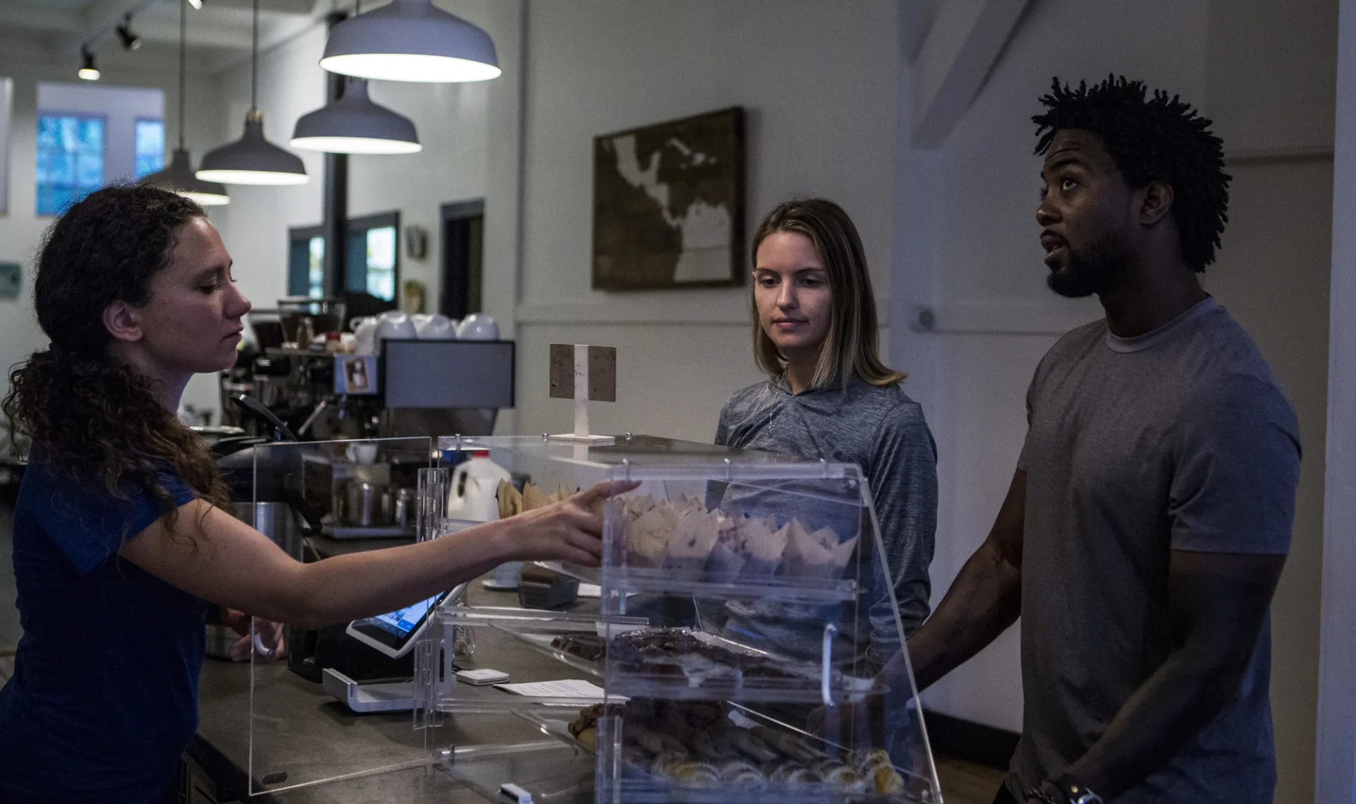 A man and woman order at a coffee shop. 