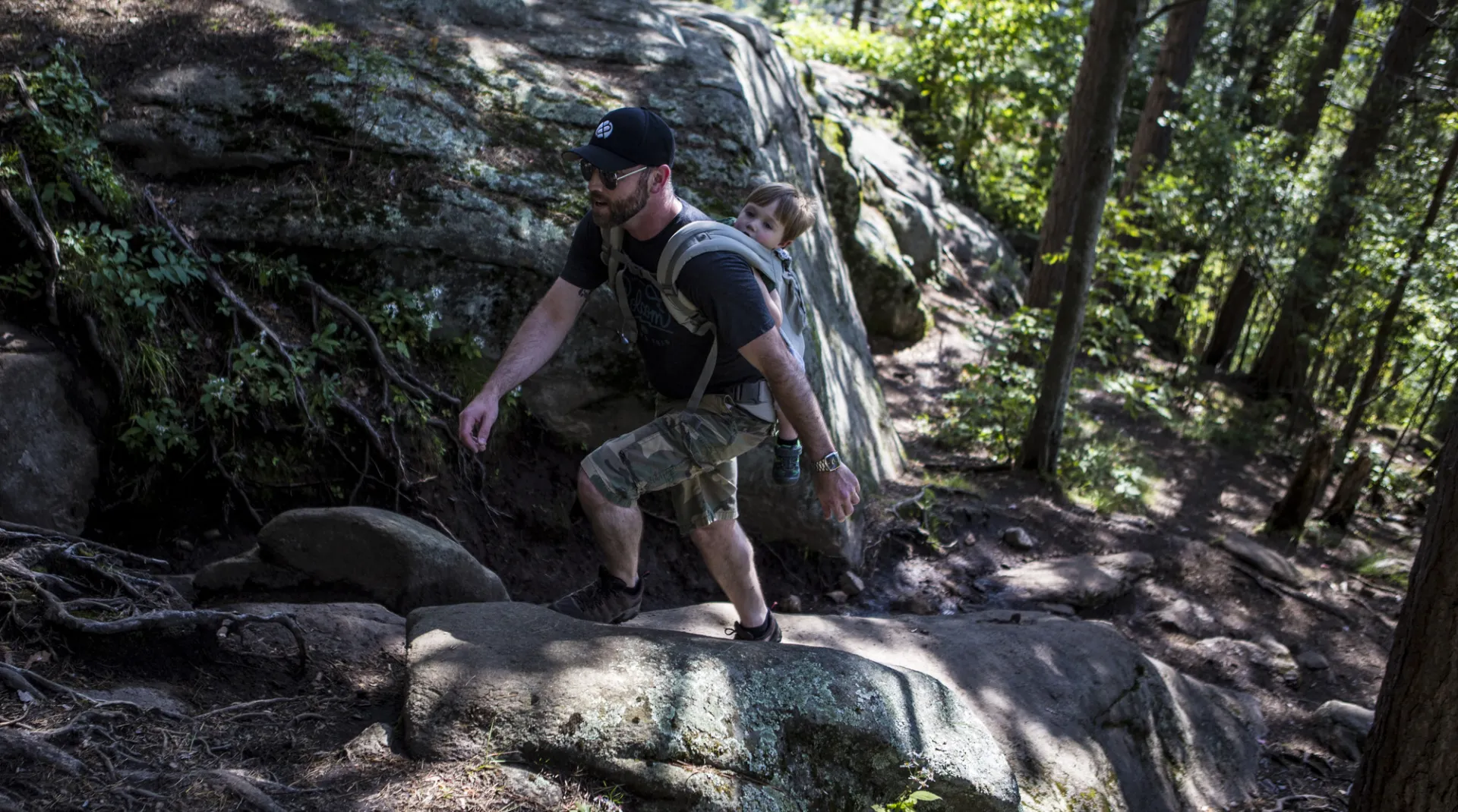 A man ascends a rocky part of the trail to the top of Baker Mountain