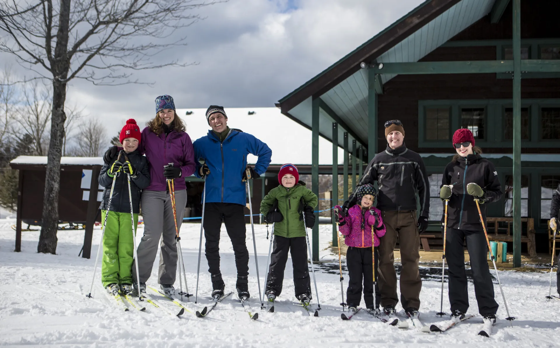 Two happy families pose for a photo in front of the Dewey Mountain Lodge