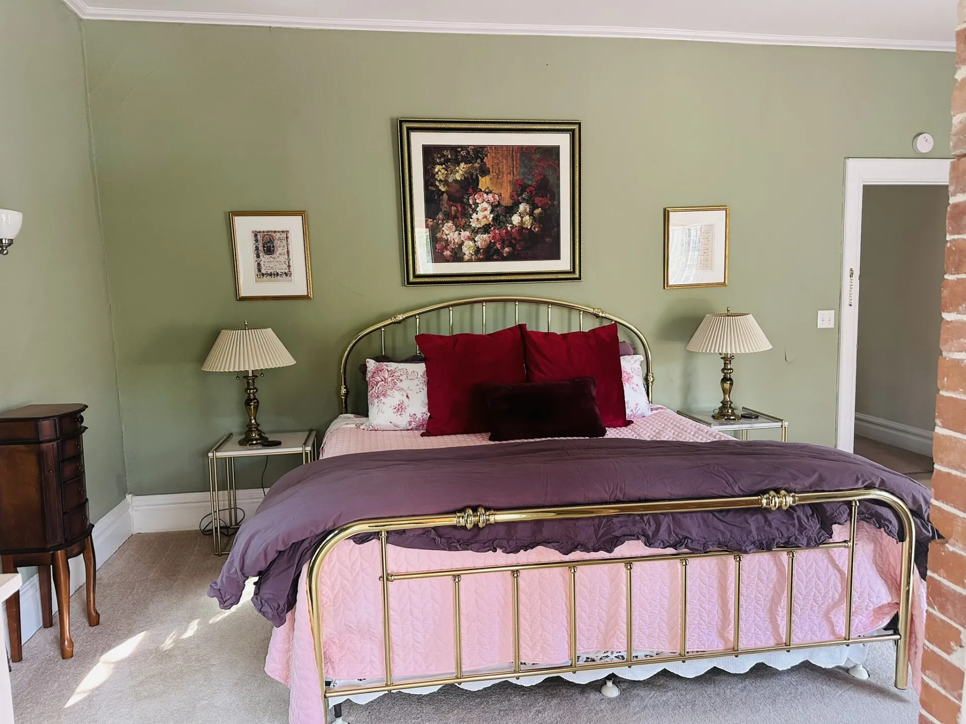 Olive green walls and gold metal bed frame transport you back in time