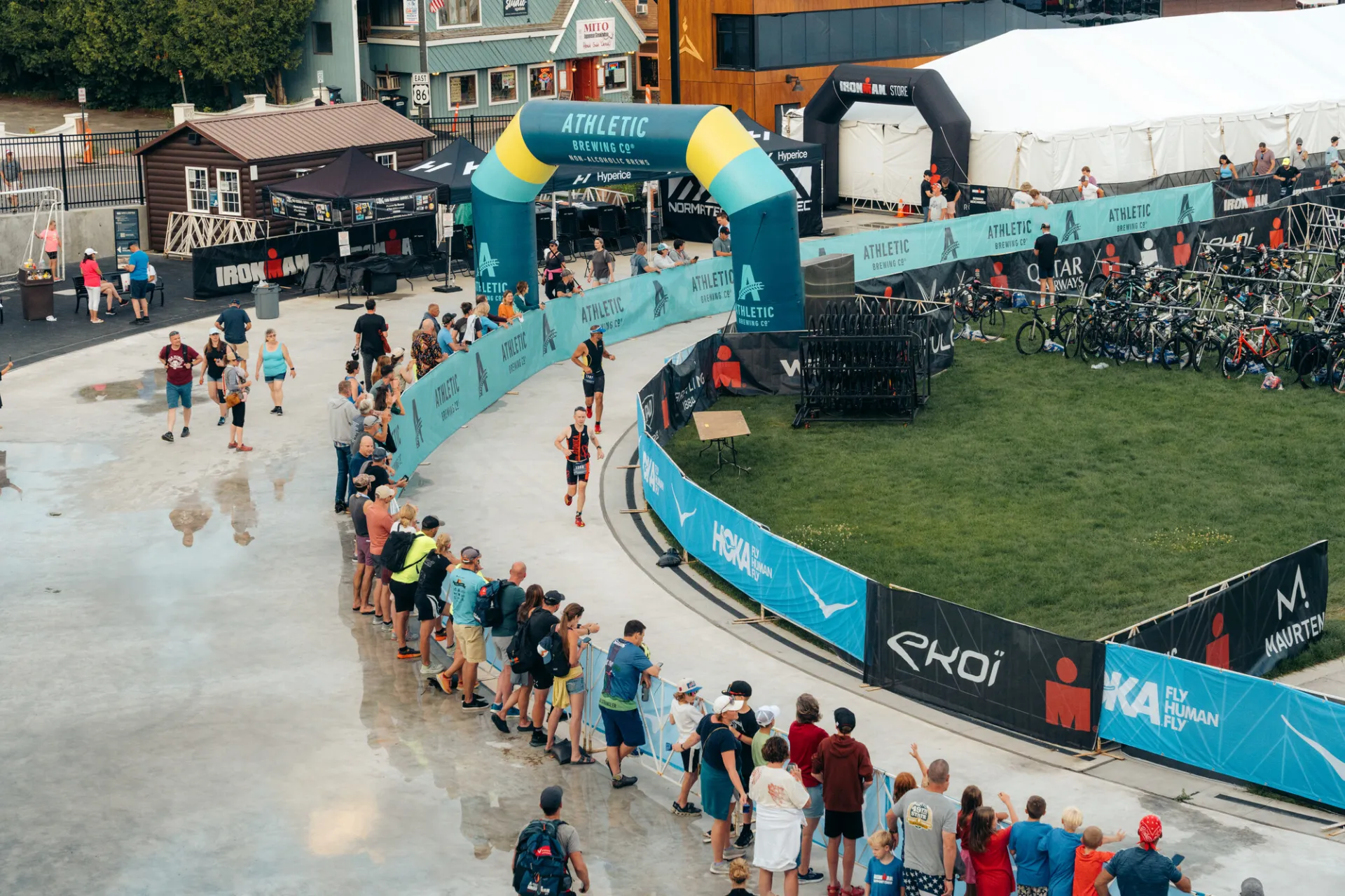 Ironman athletes running on oval with spectators watching