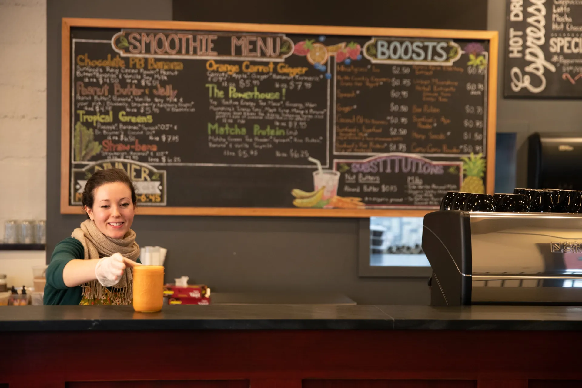 A woman serves up an order at a colorful cafe. 