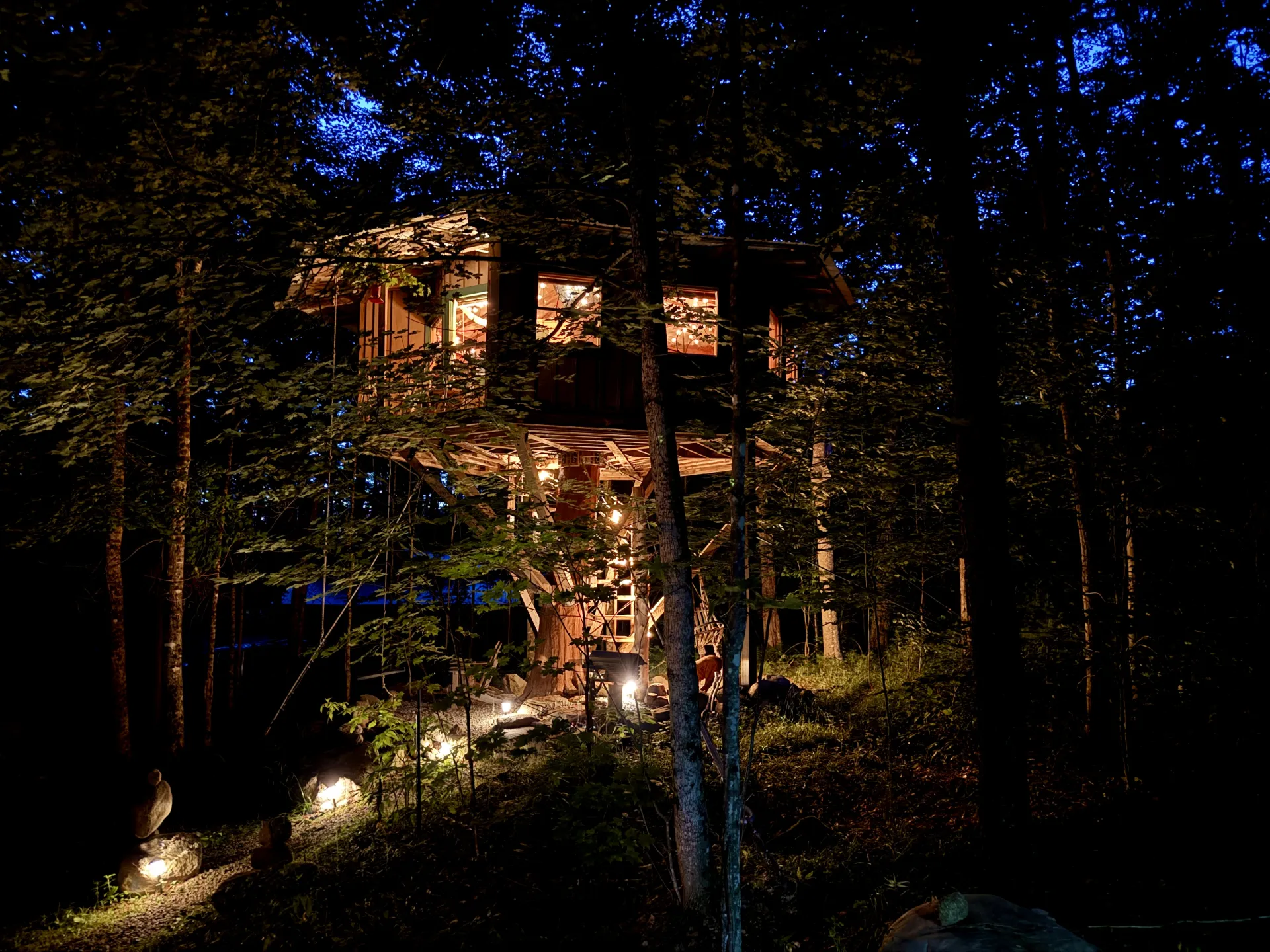 A tree house in the woods at night.