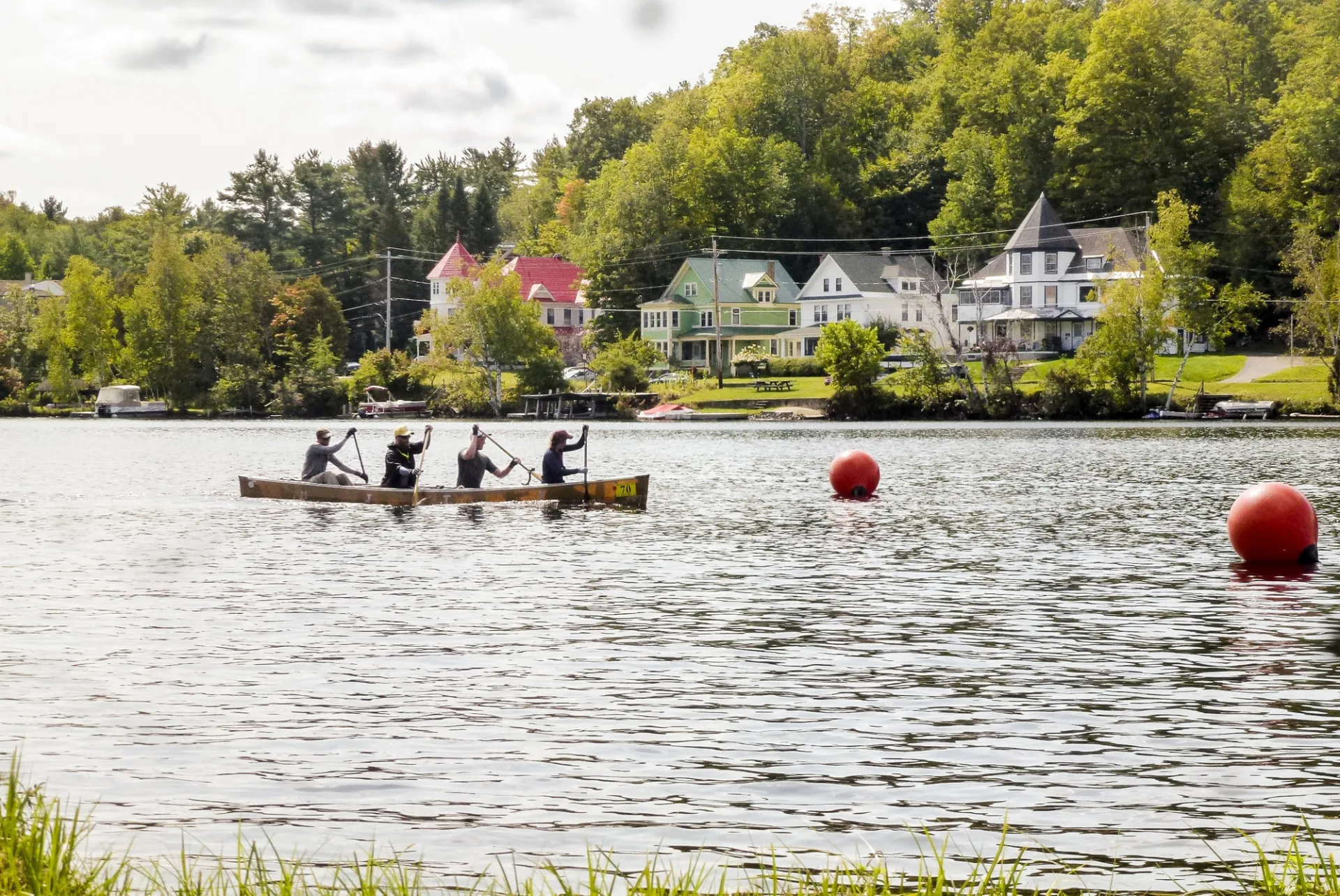 A team of four paddle a canoe down a river