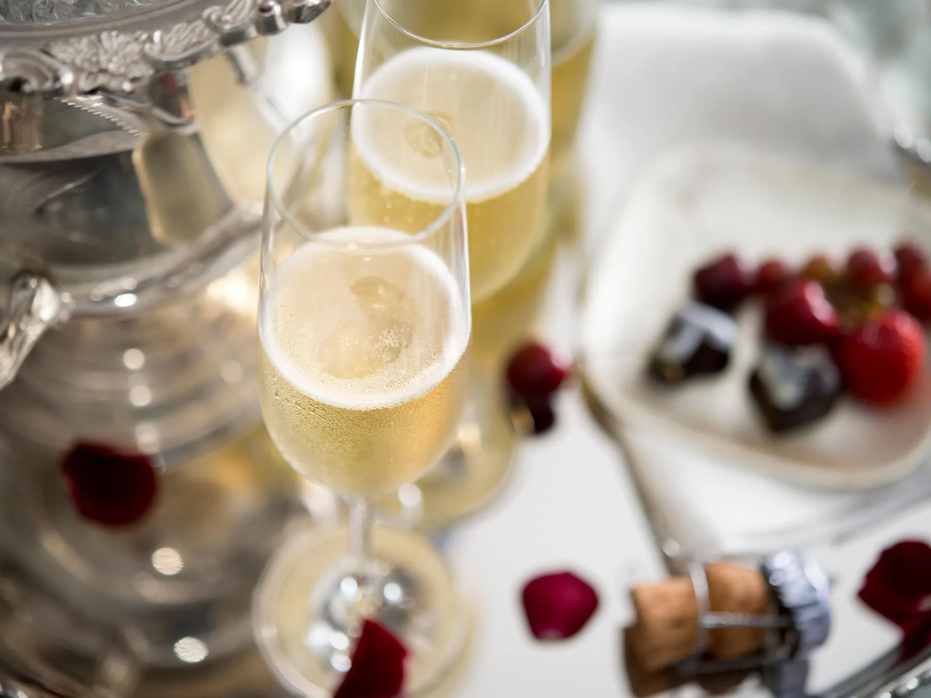 Champagne in flutes with scattered berries