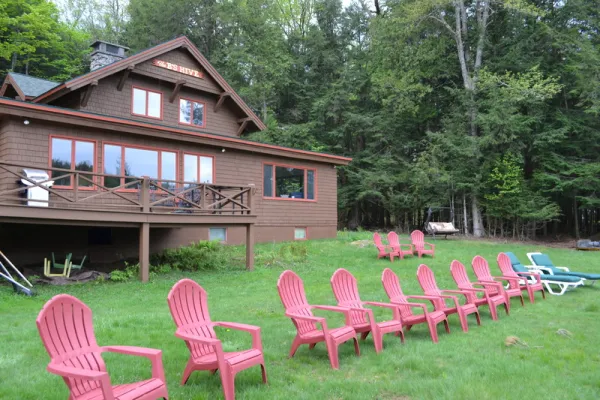 Endless row of red adirondack style chairs on the lawn