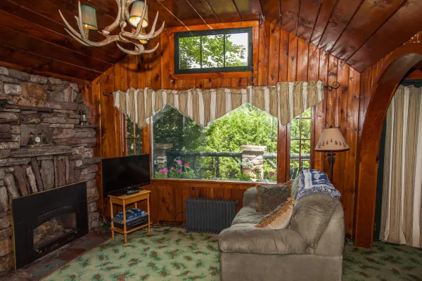 The sitting room with large window and stone fireplace.